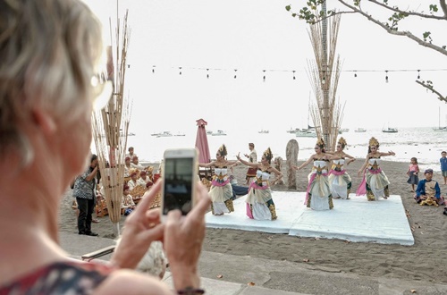 Seorang wisman sedang memotret tarian tradisional di Bali. Foto kemenparekraf.go.id.