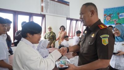 Kepala Kejaksaan Negeri (Kejari) Karo, Darwis Burhansyah membagikan MBG kepada murid SLB Negeri Berastagi. Foto Rienews.com.