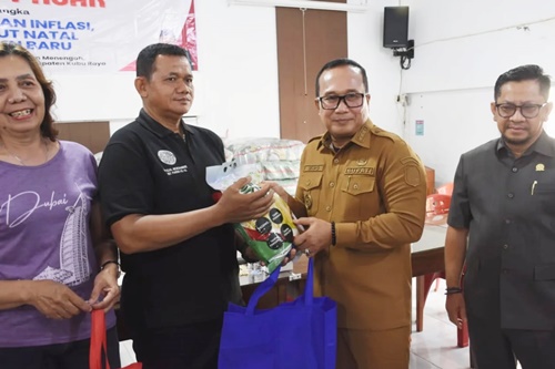 Bupati Kubu Raya Sujiwo secara simbolis menyerahkan paket sembako kepada pihak Gereja Paroki Santo Agustinus pada pelaksanaan Operasi Pasar di Aula Gereja Paroki Santo Agustinus, Desa Parit Baru, Senin, 8 Desember 2025. Foto Istimewa.